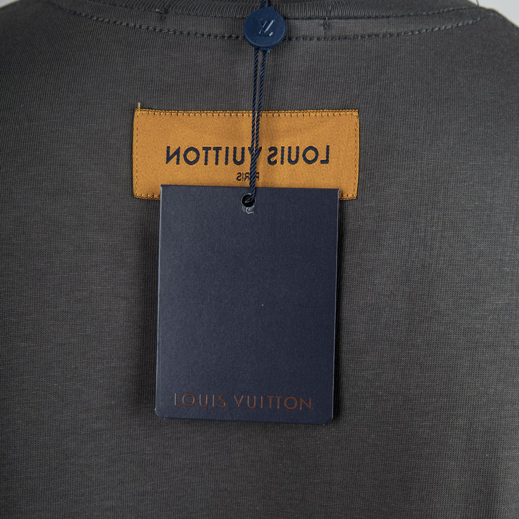 Louis Vuitton clothing tag attached to dark gray T-shirt with yellow header