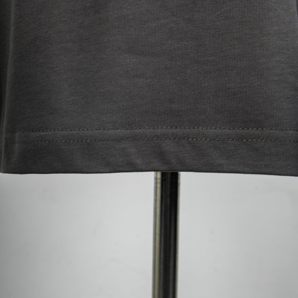 Dark gray T-shirt hem stitching along the bottom edge