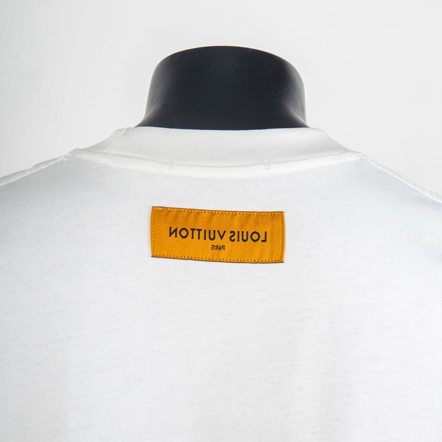 White T-shirt with yellow neck label patch on the back