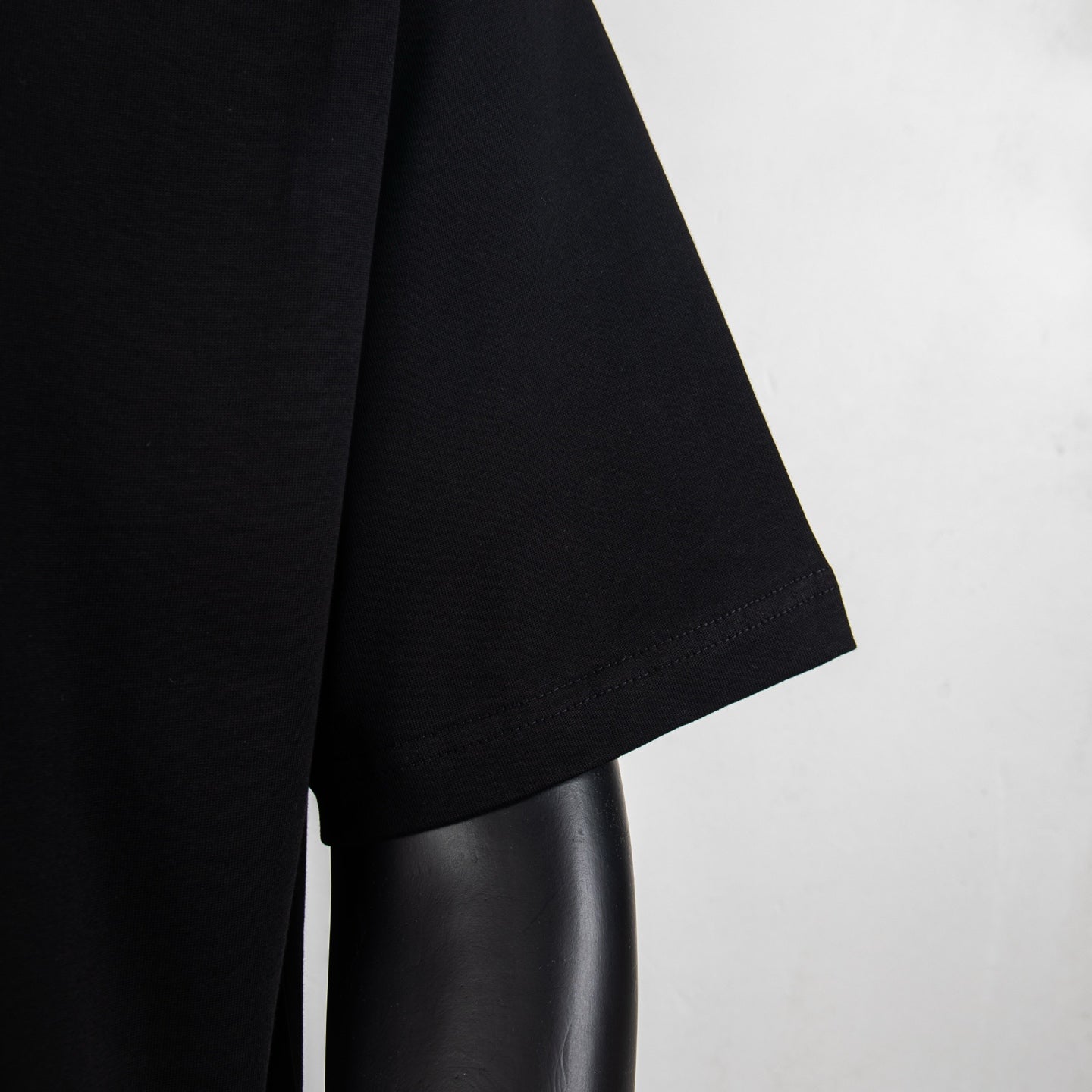 Black T-shirt sleeve and hem close-up