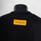 Black T-shirt back with yellow rectangular logo label
