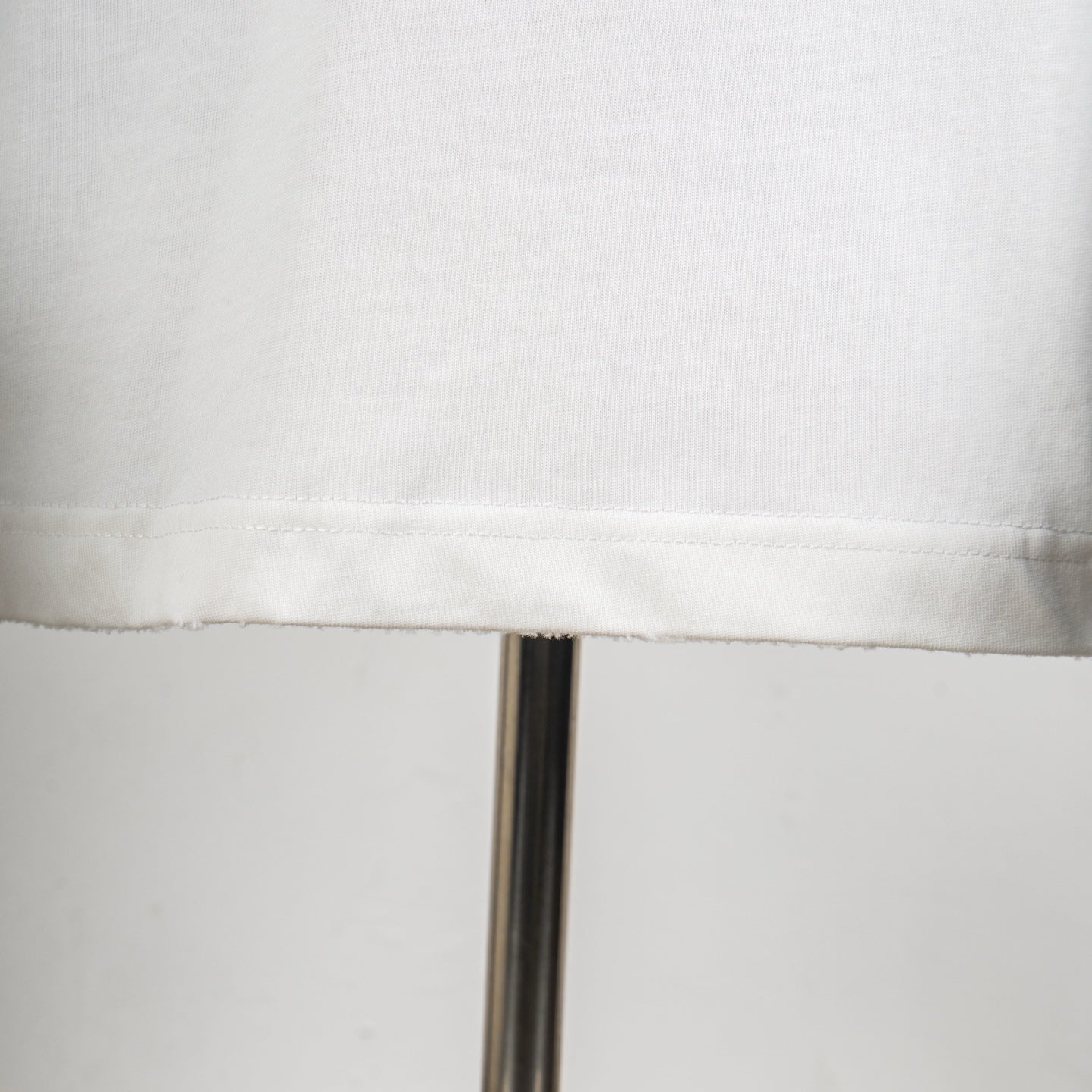 White T-shirt hem seam detail with stitched bottom edge