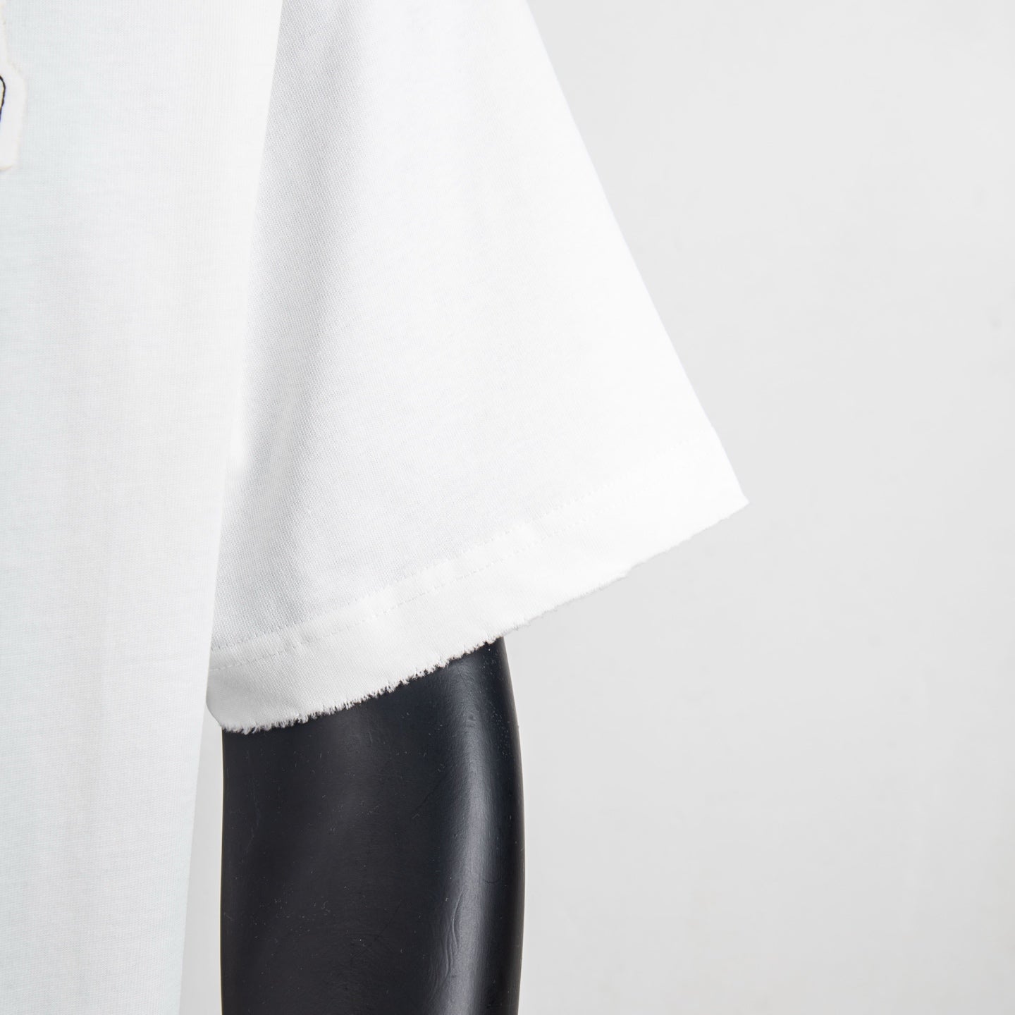 White T-shirt sleeve and curved hem with visible stitching