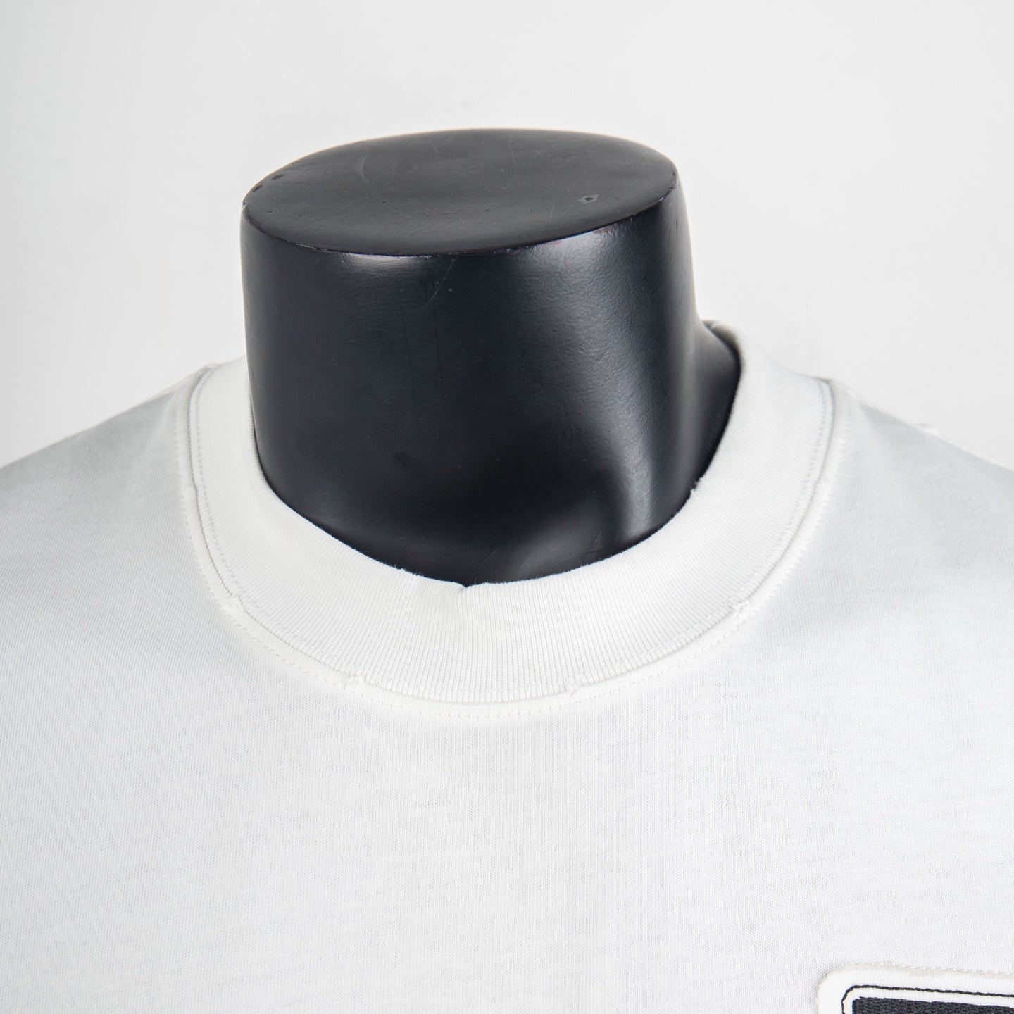 White graphic T-shirt neckline detail with smooth crew neck collar