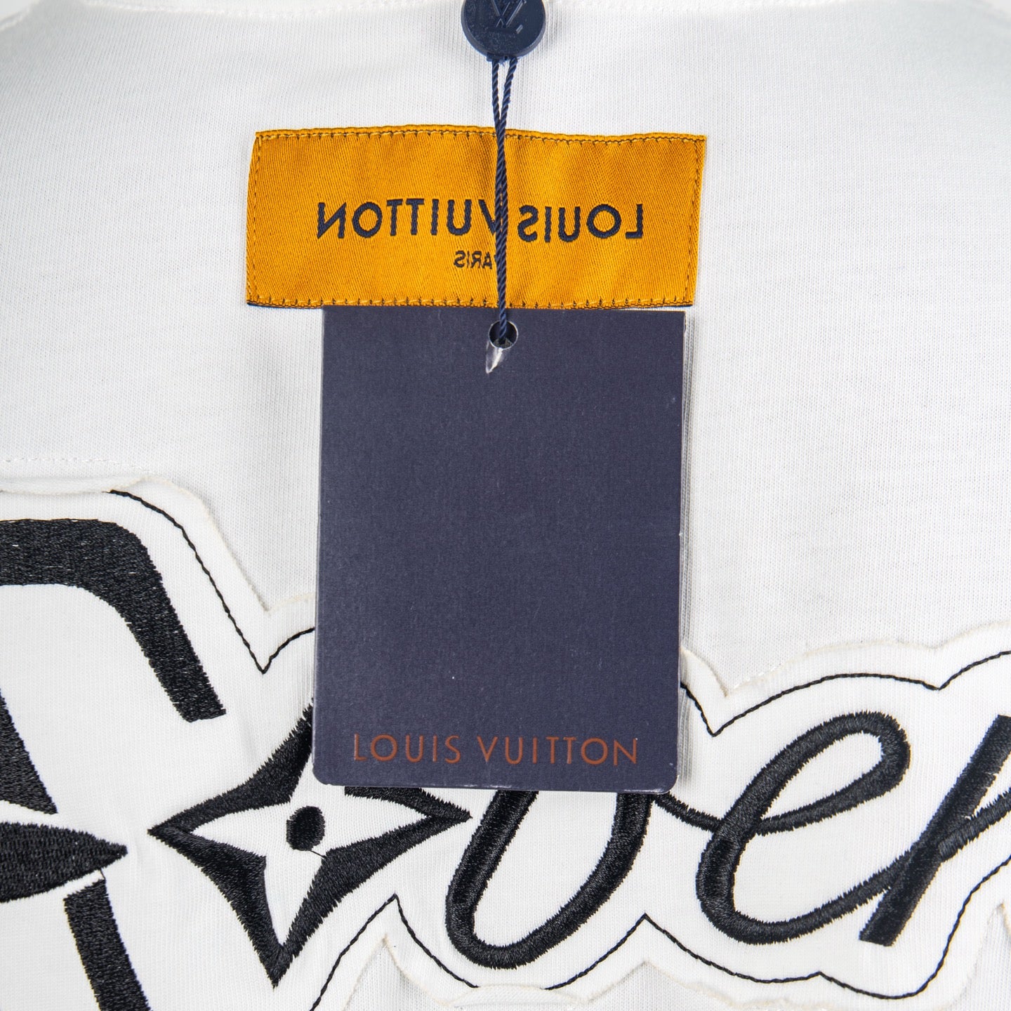 Neck label and price tag area on white T-shirt with Louis Vuitton branding