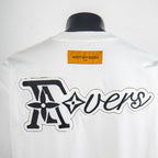 White back graphic T-shirt with large cursive “Traders” logo