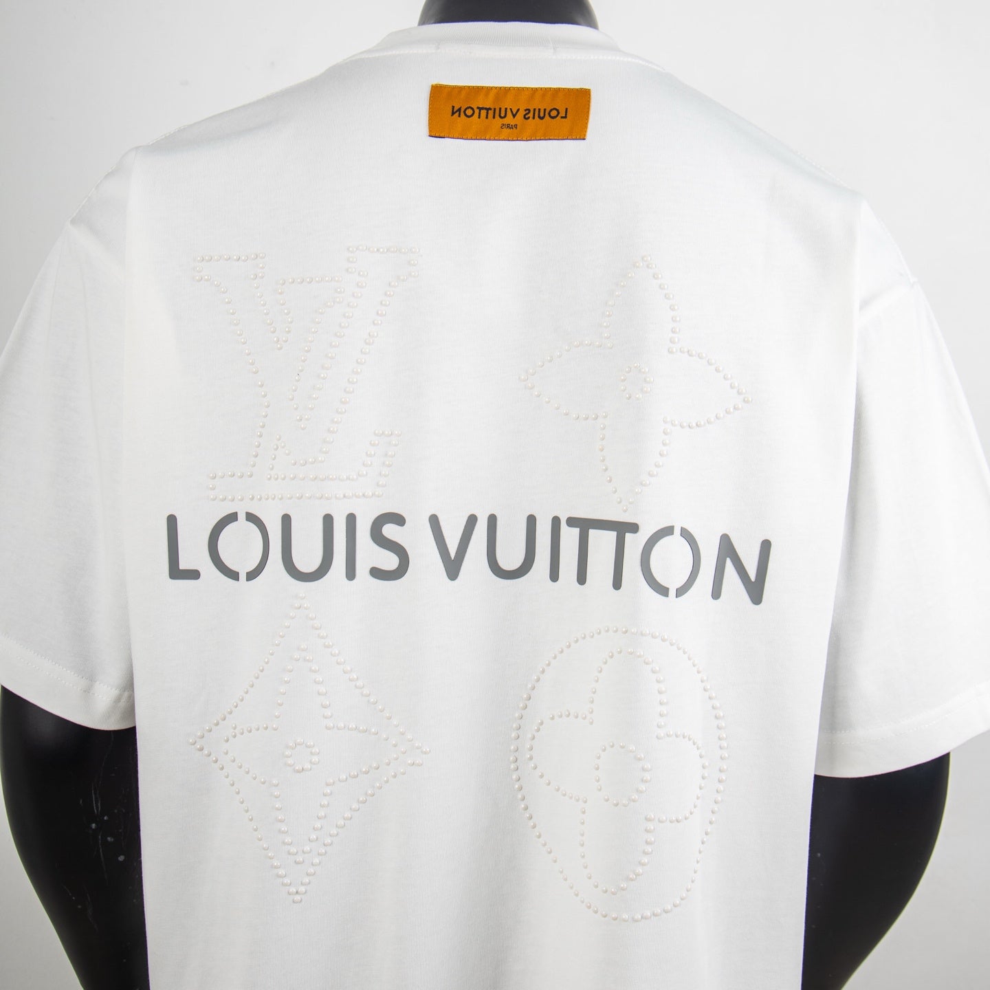 White T-shirt back with large Louis Vuitton text and embossed monogram motifs