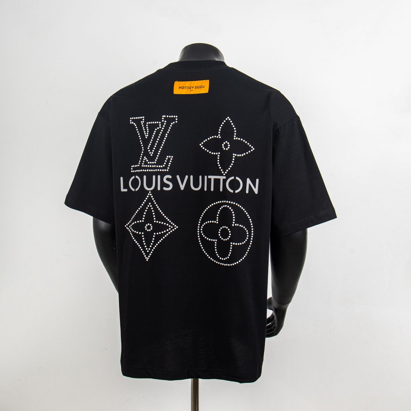 Black T-shirt back with large Louis Vuitton rhinestone symbols and yellow neck tag