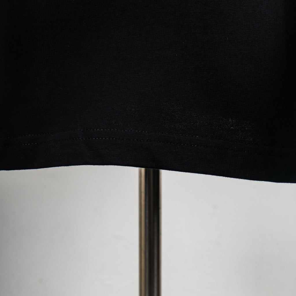 Black T-shirt hem with visible stitching and straight bottom edge