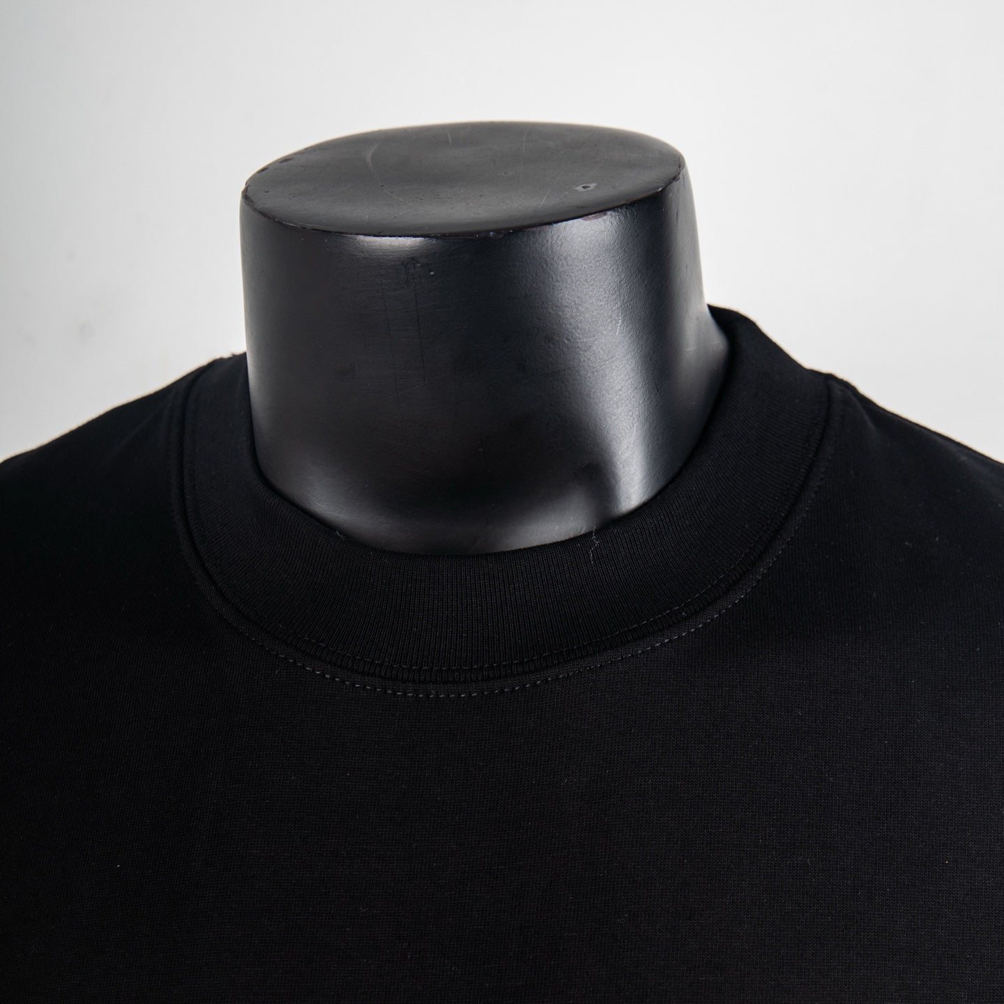 Black T-shirt neckline detail with ribbed crew neck collar