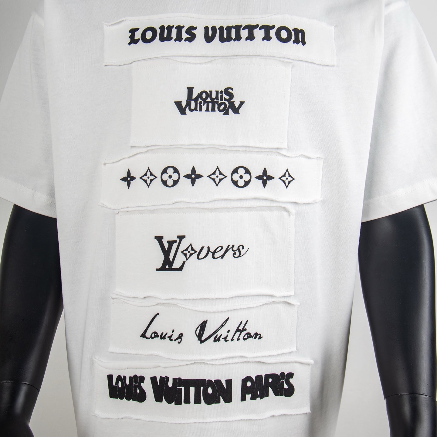 White T-shirt front with layered black logo graphics and star-flower motifs