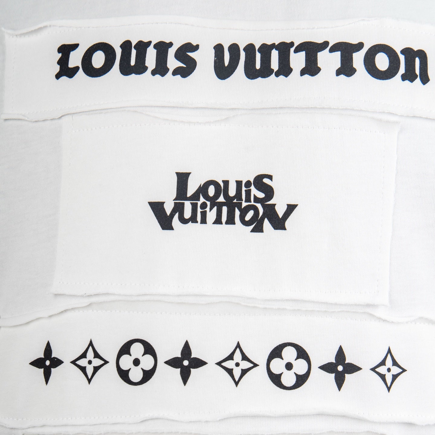 White T-shirt chest panel with black Louis Vuitton logo and decorative emblems