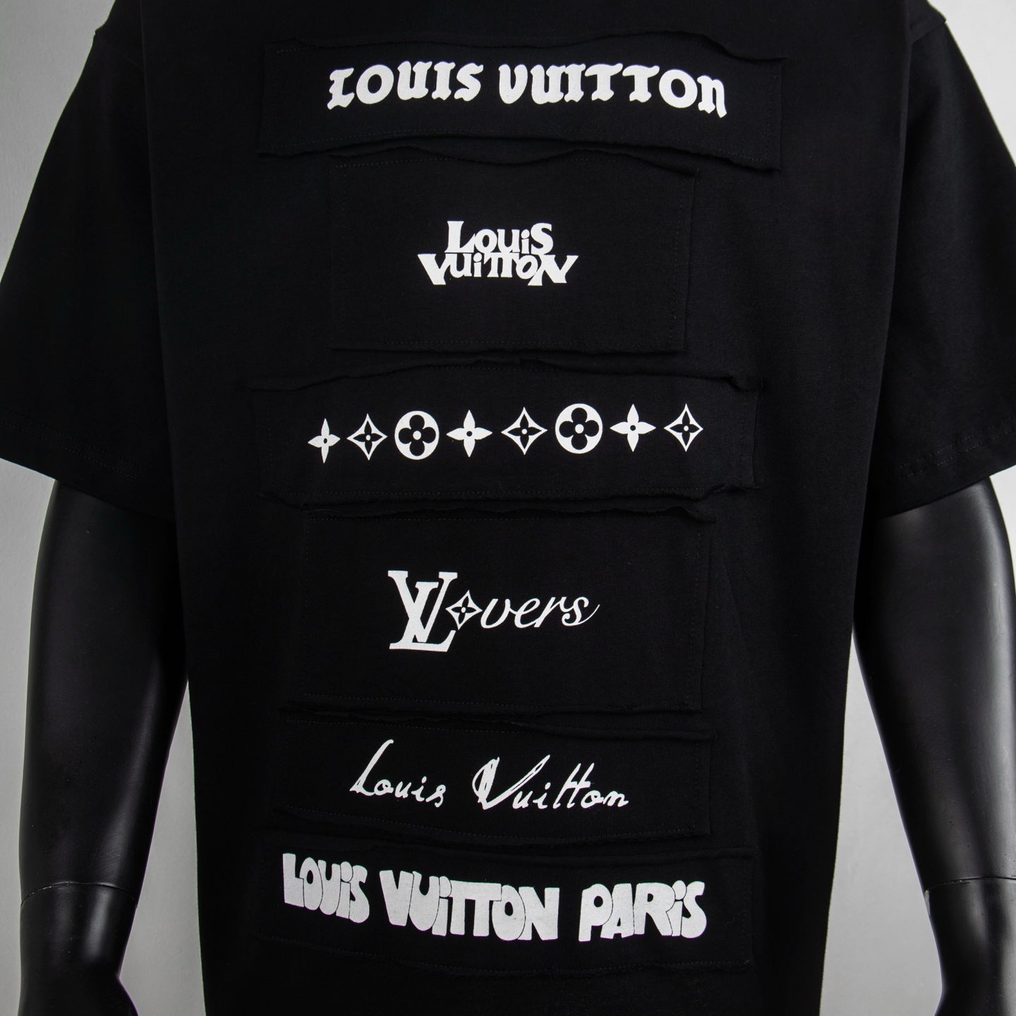 Black graphic T-shirt with stacked Louis Vuitton logos and emblem print