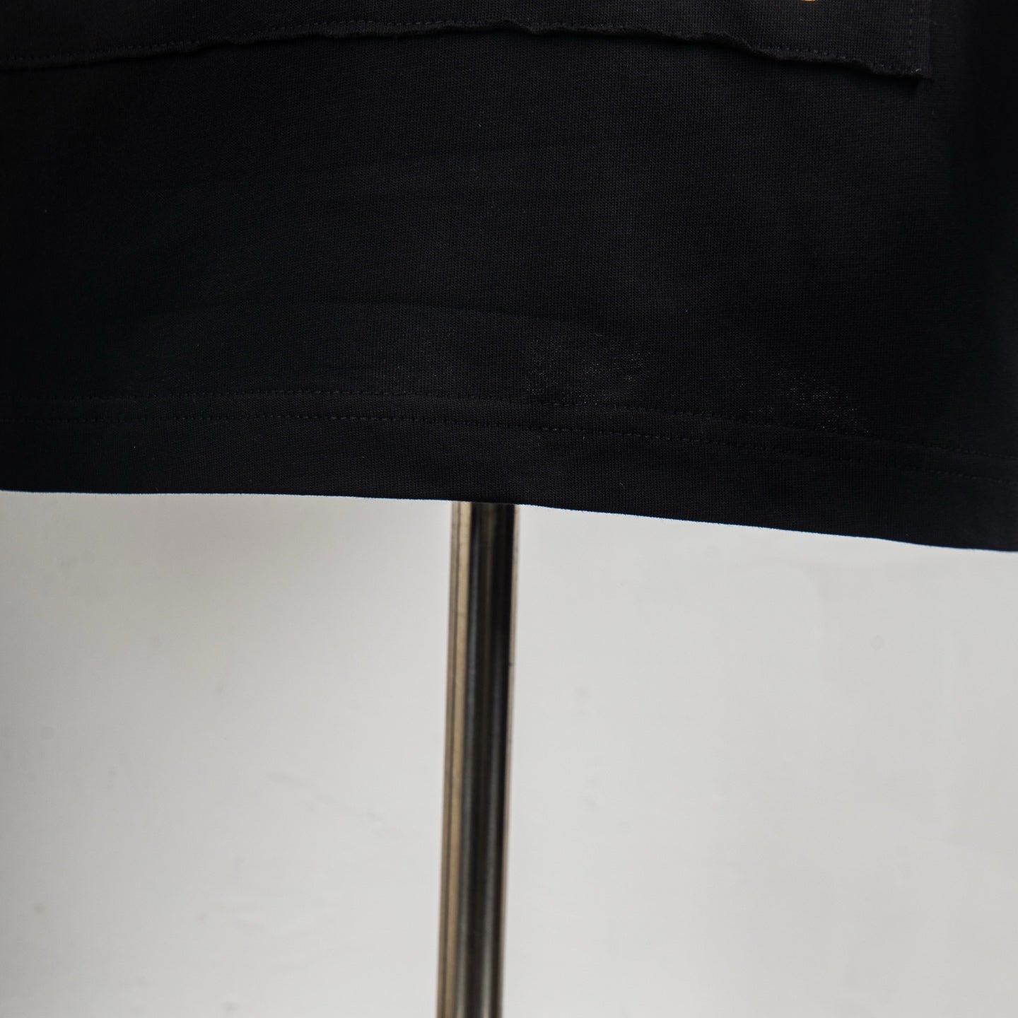 Black T-shirt hem with visible stitching
