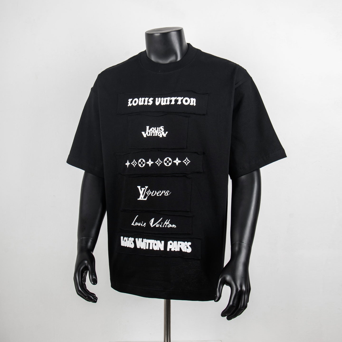 Black graphic T-shirt with Louis Vuitton logo patches on the front