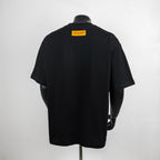 Black graphic T-shirt back view with yellow Louis Vuitton label