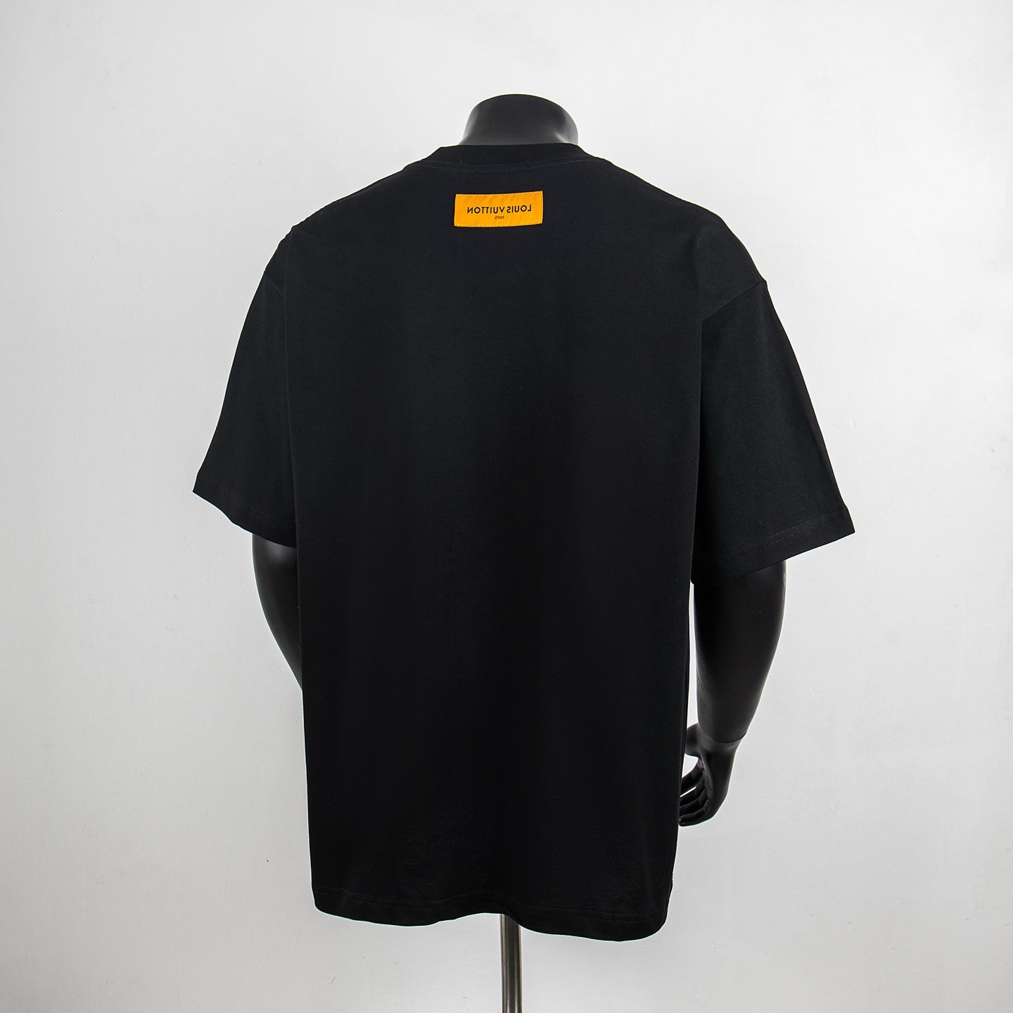 Black graphic T-shirt back view with yellow Louis Vuitton label