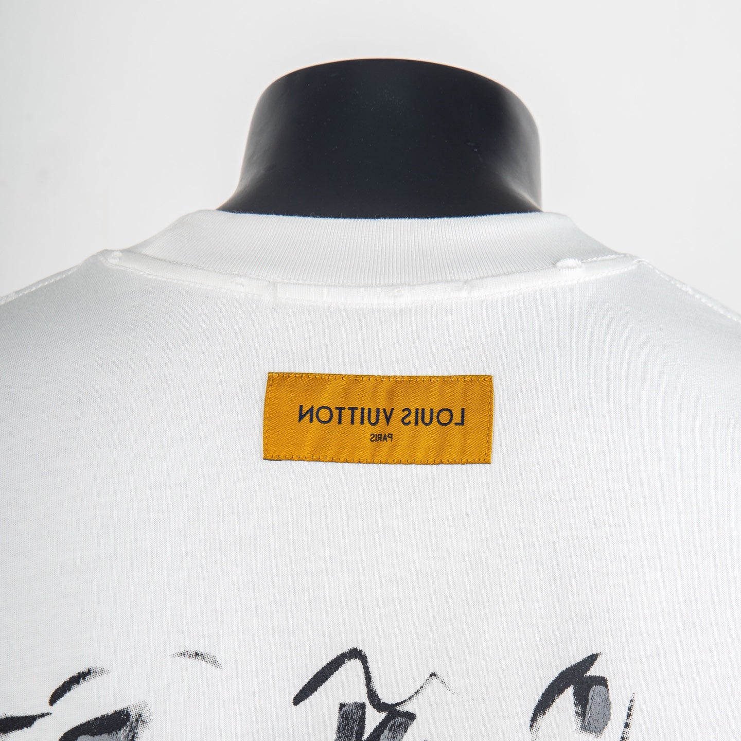 White T-shirt with yellow brand tag on back collar