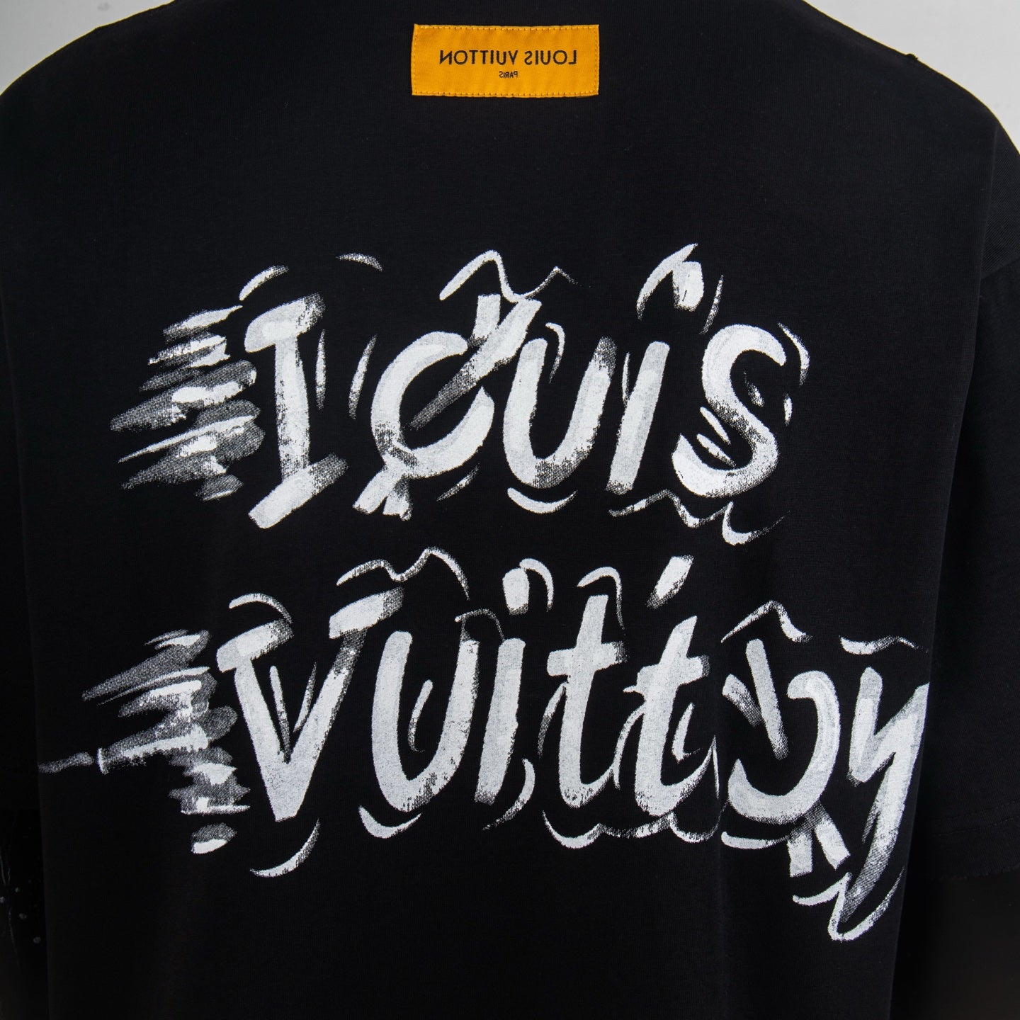 Black short-sleeve T-shirt with large white LV script logo on back