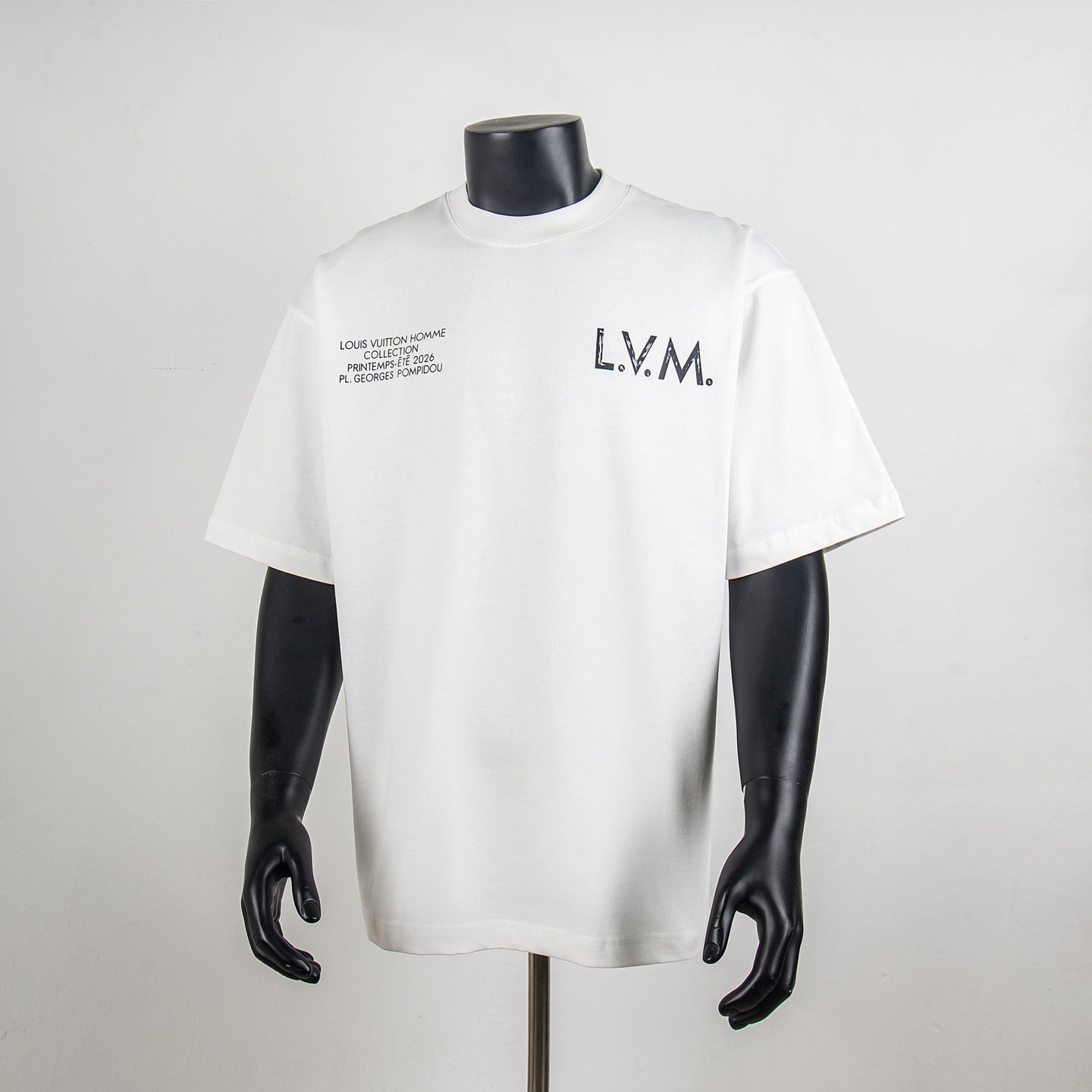 White crewneck T-shirt with 'L.V.M.' logo and small text print at chest