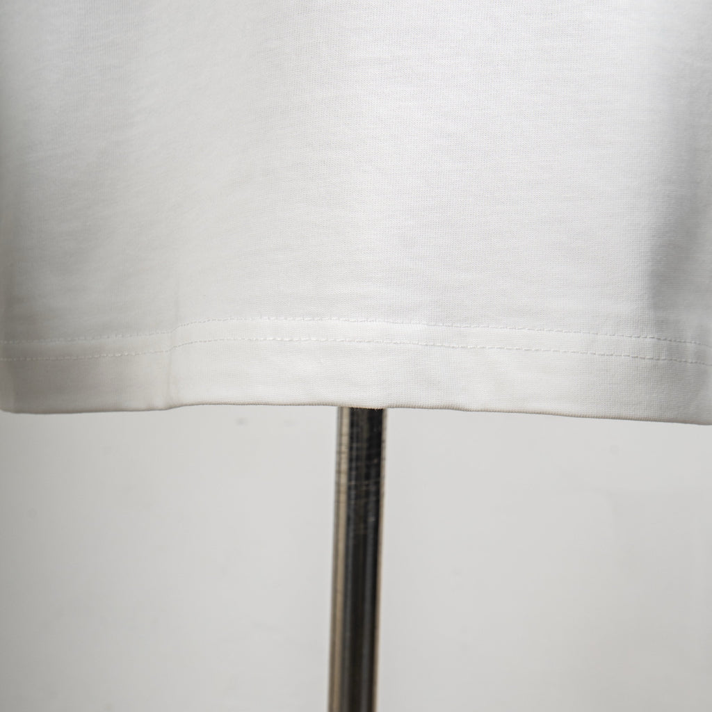 White T-shirt lower hem and visible stitching close-up