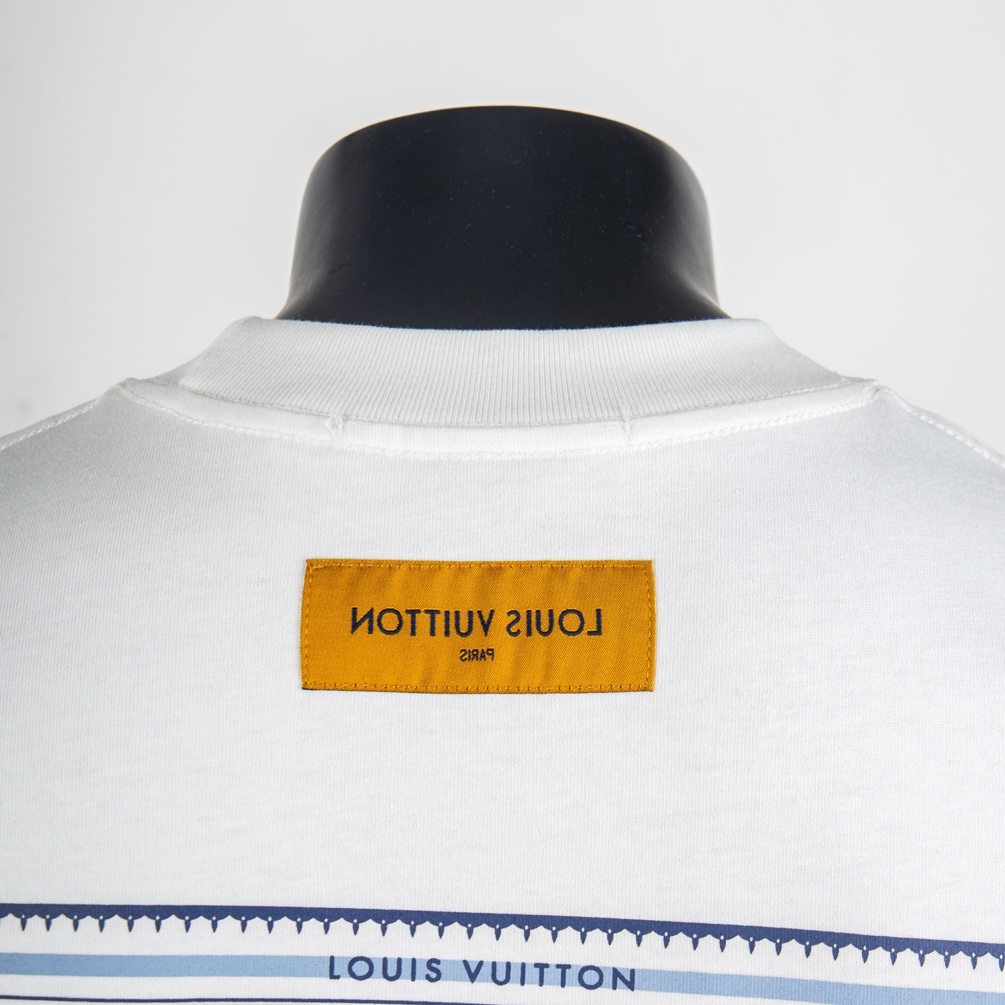 White T-shirt with orange neck label and “Louis Vuitton” text