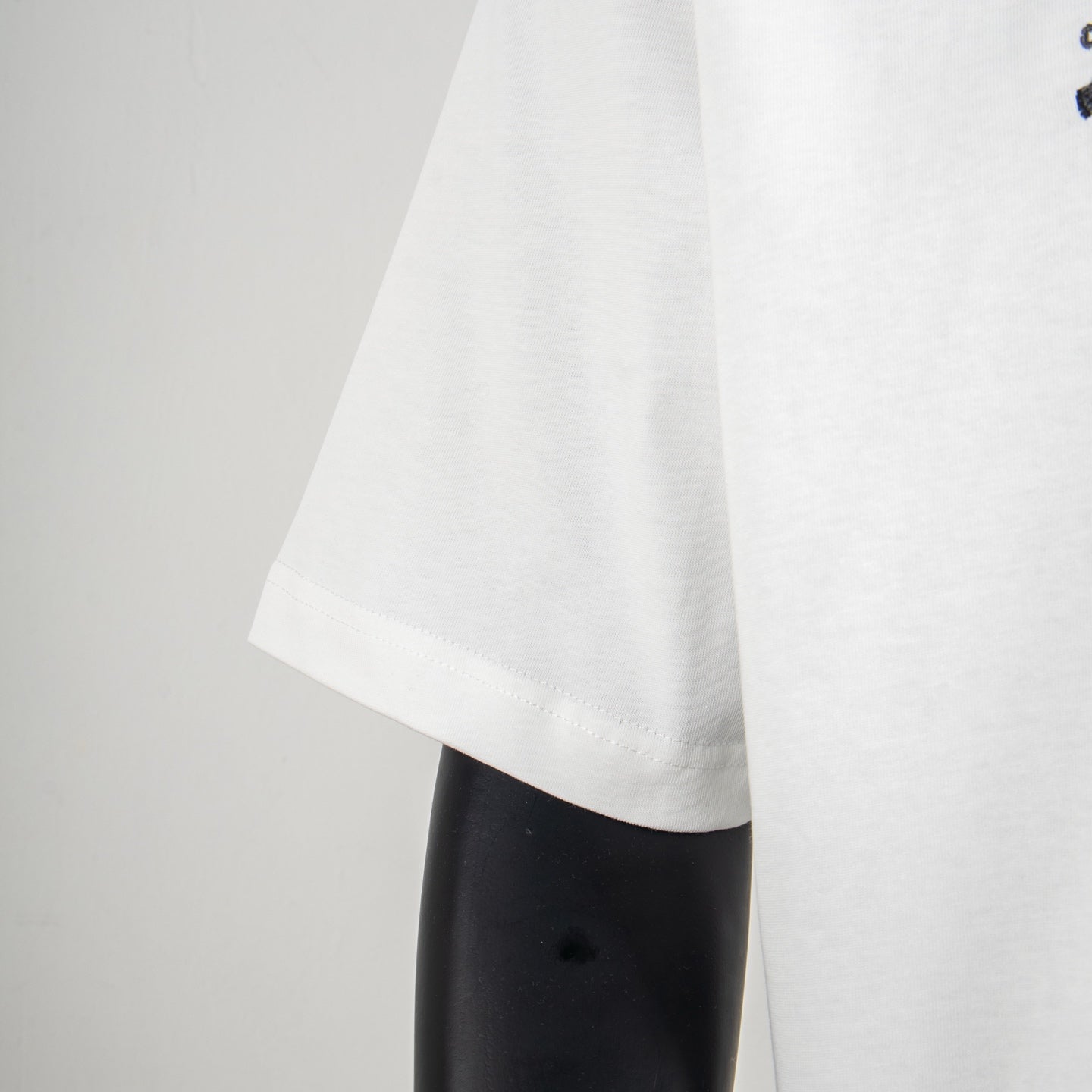 Louis Vuitton white T-shirt side view with stitched hem and straight cut bottom