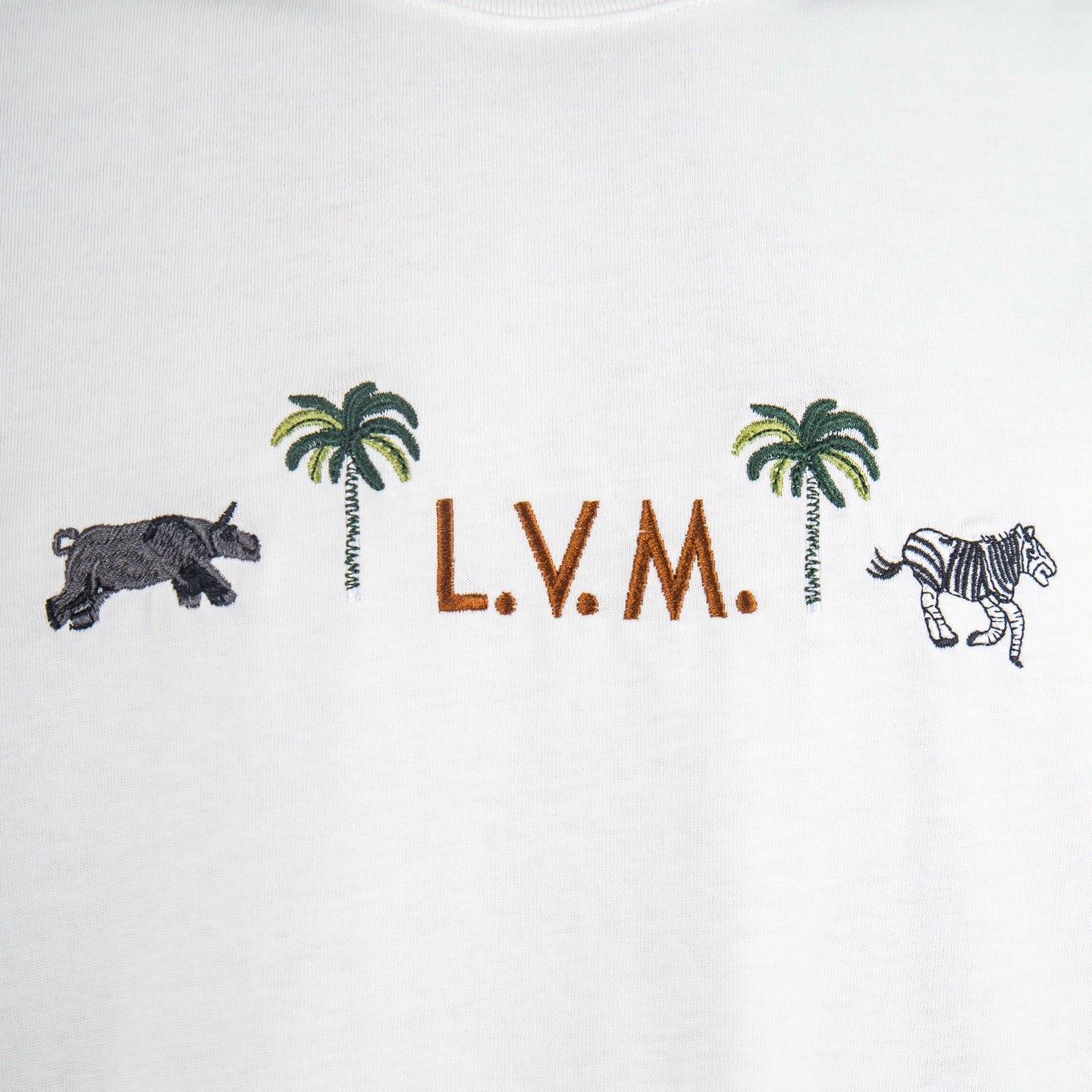 White T-shirt chest graphic with palms, animals, and L.V.M. text