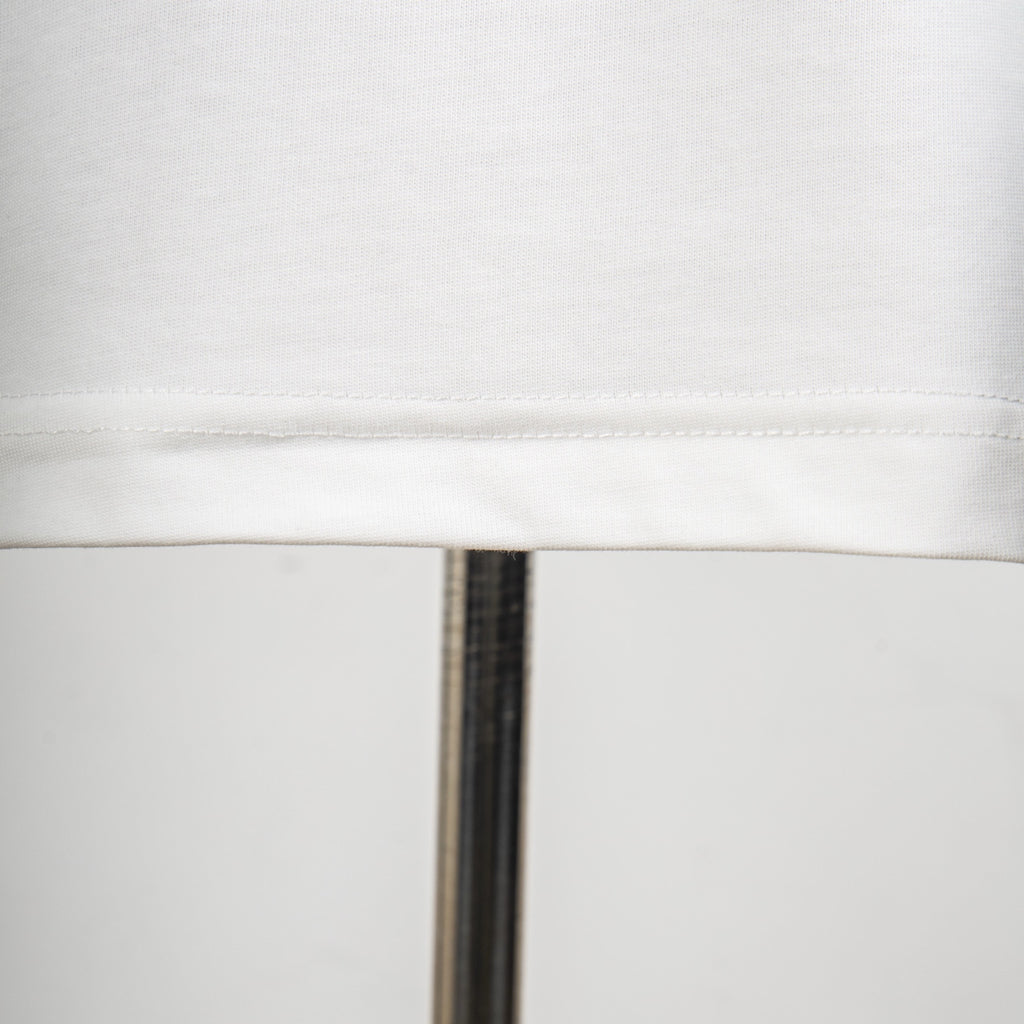 White T-shirt hem seam close-up with neat stitched edge