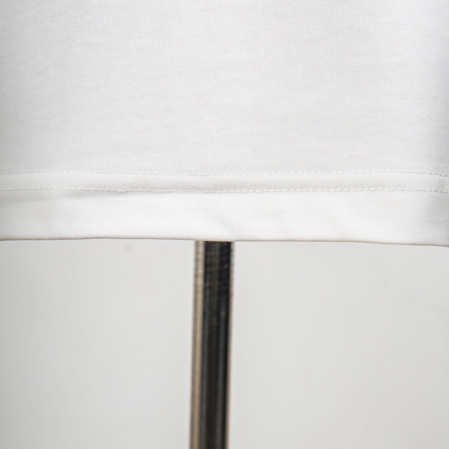 White T-shirt hem seam close-up with neat stitched edge
