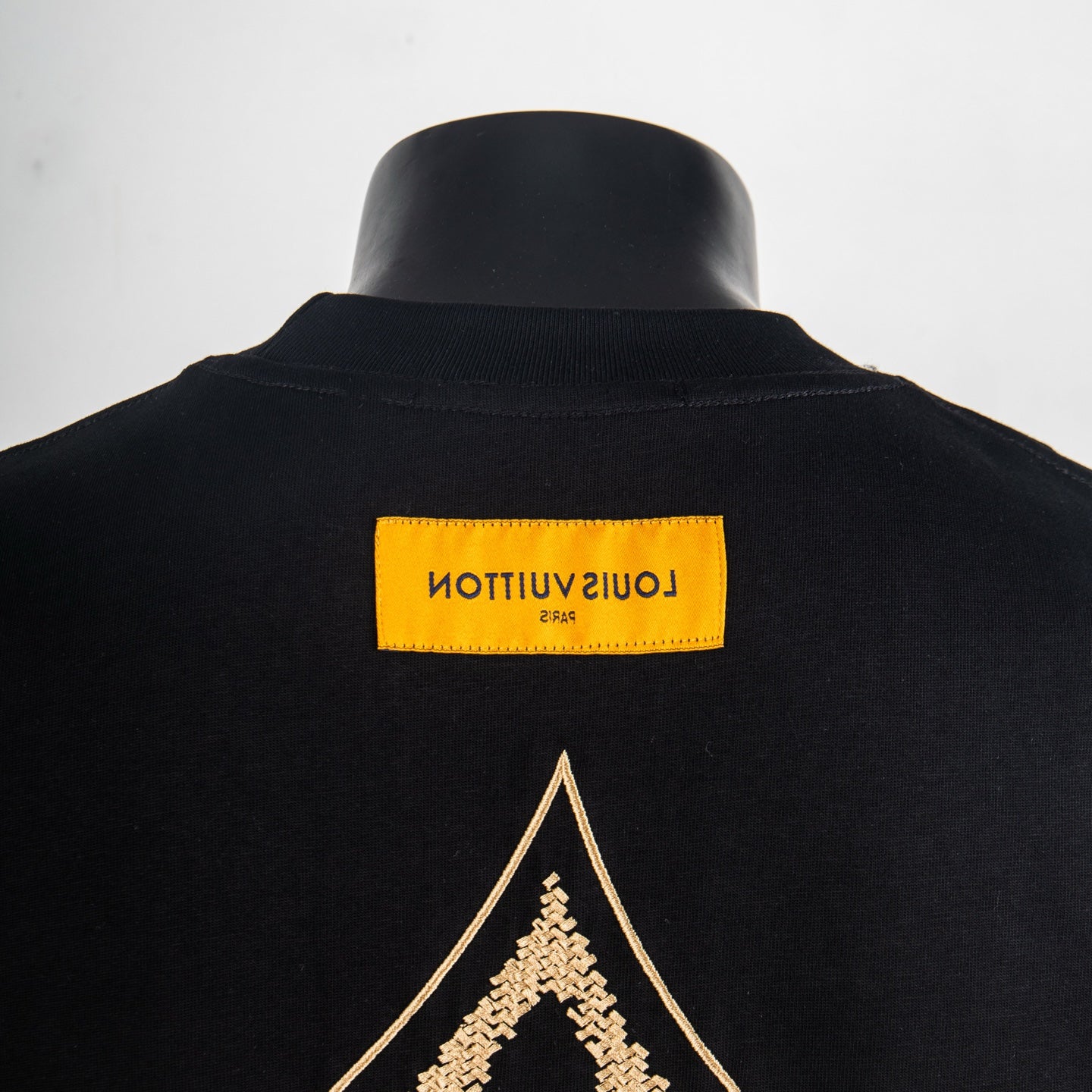 Louis Vuitton T-shirt back neckline with yellow brand label and gold diamond emblem