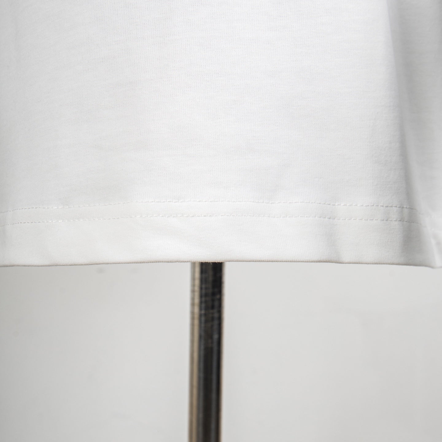 Givenchy white T-shirt hem close-up with visible stitching