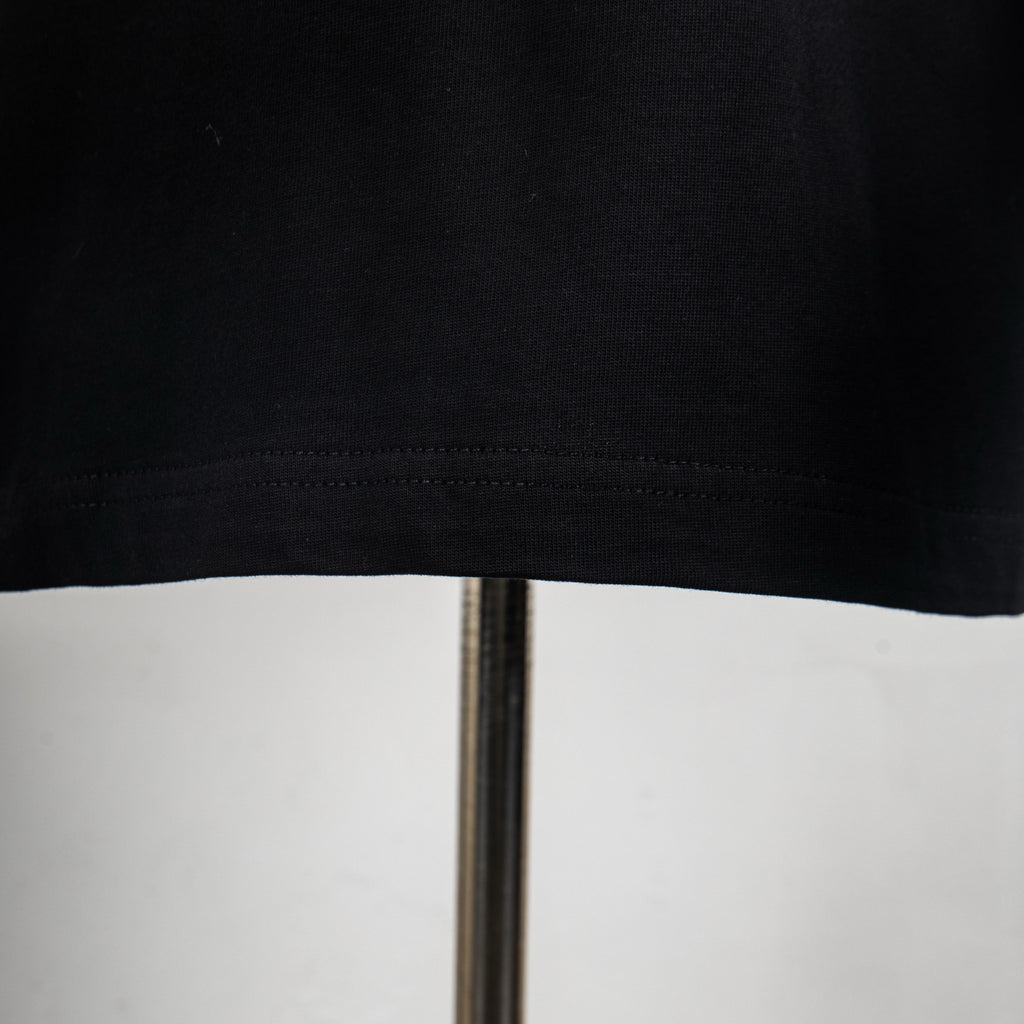 Black T-shirt hem stitching and lower seam detail