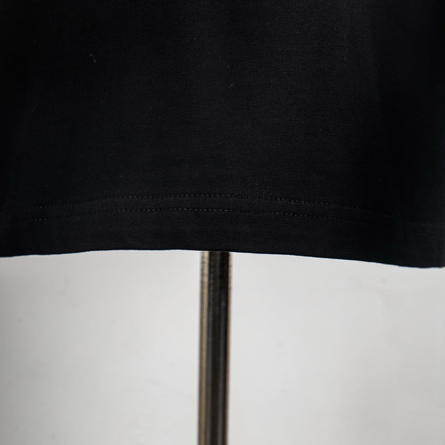Black T-shirt hem with visible stitching detail