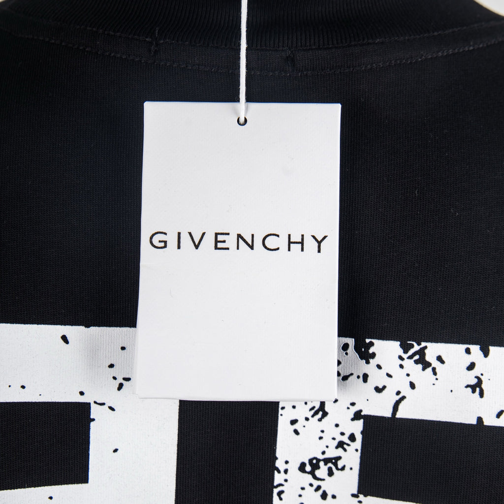 Black T-shirt with white hang tag at neckline reading Givenchy