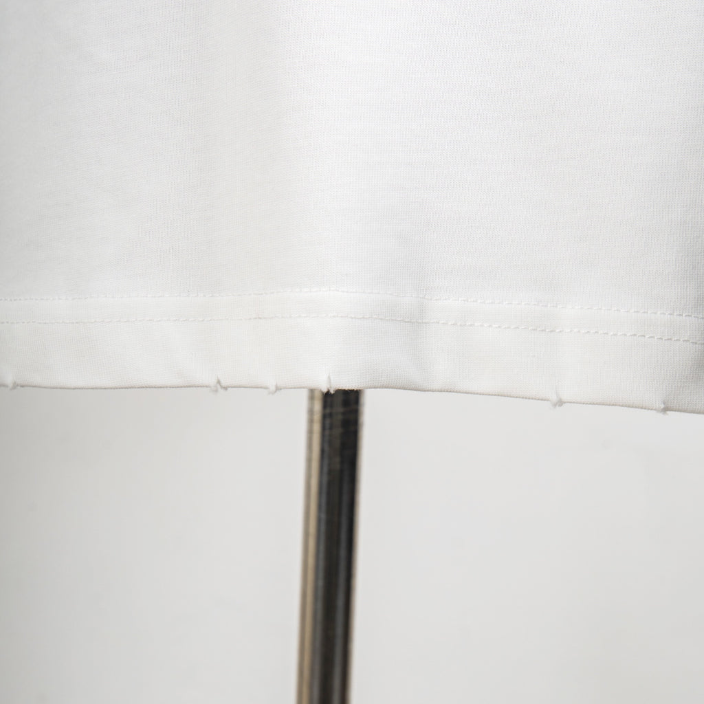 White T-shirt seam and stitching detail near hem