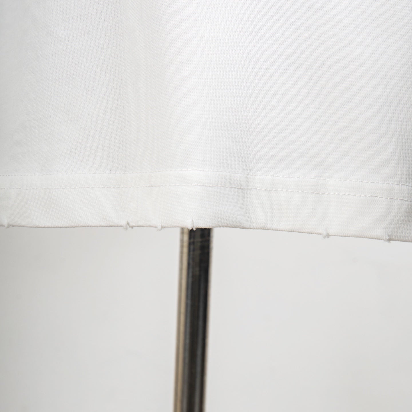 White T-shirt seam and stitching detail near hem
