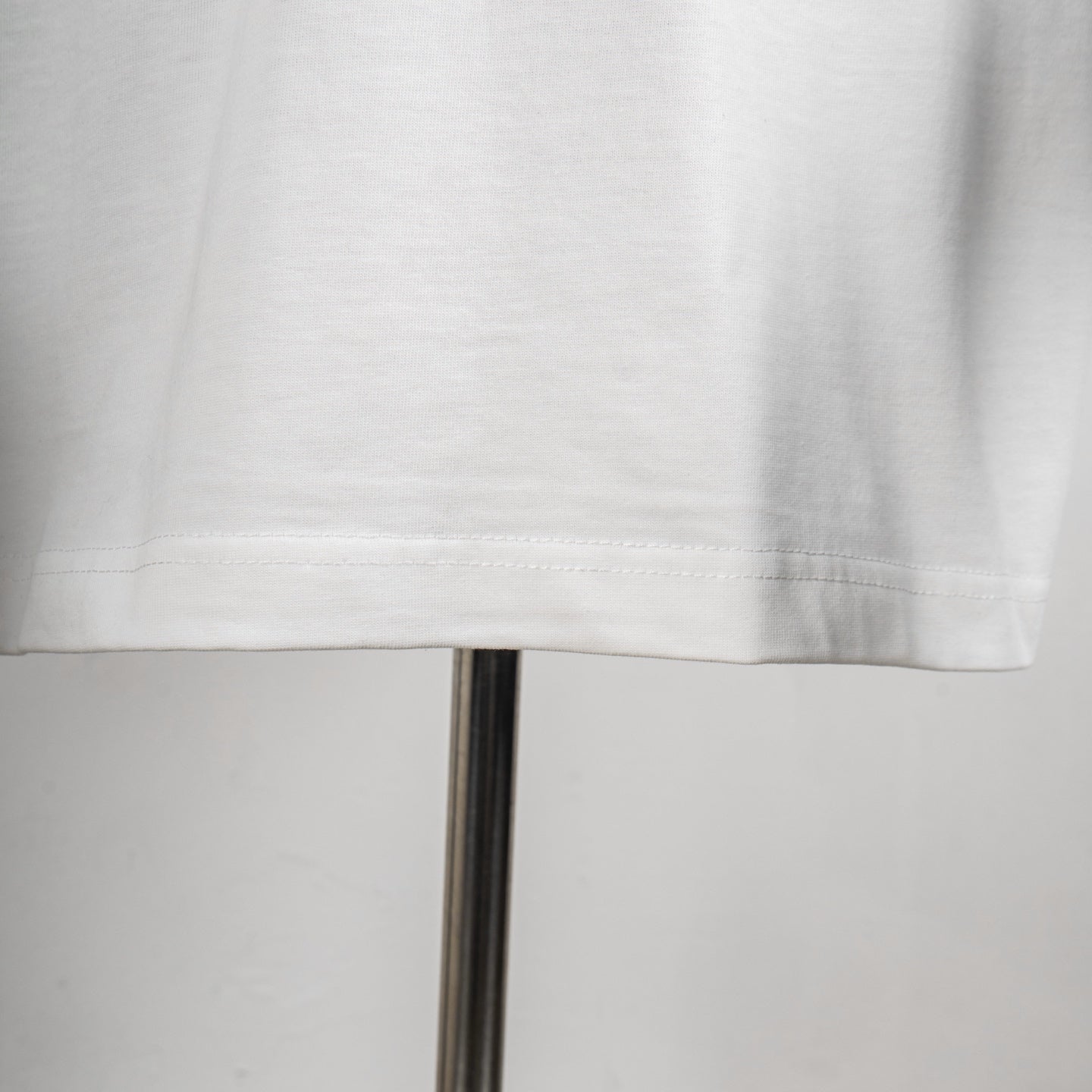 Givenchy white T-shirt hem close-up with visible stitching detail