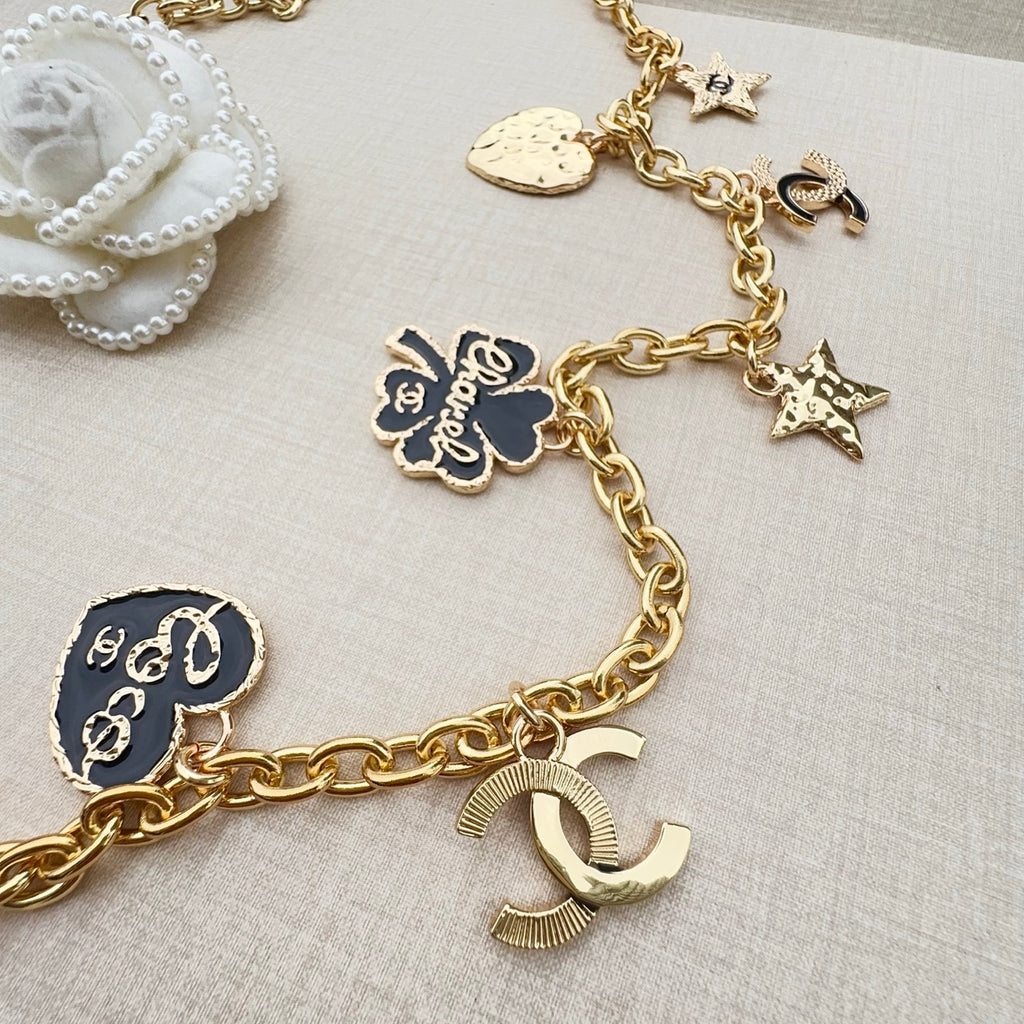 Gold-tone chain belt close-up with round medallion, star charms, and link chain details