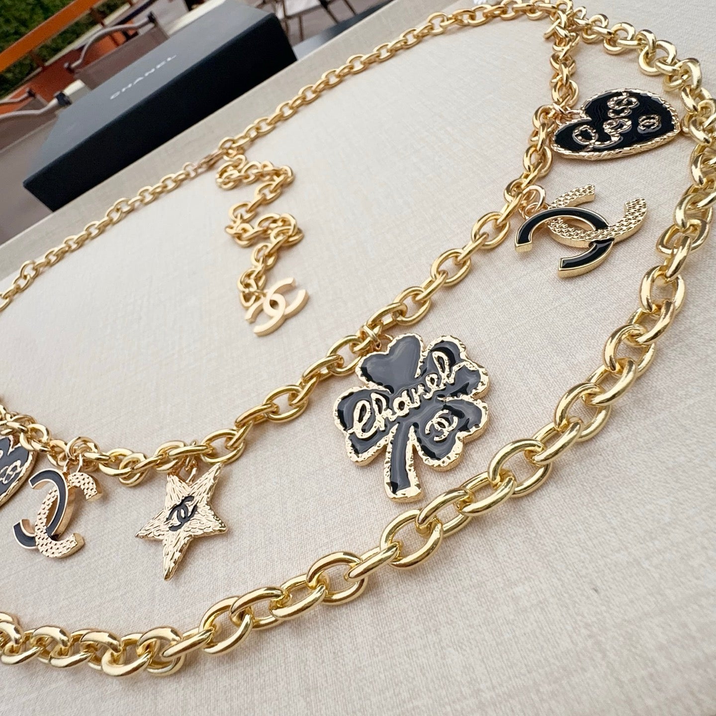 Gold-tone chain belt with CC heart medallion, star charms, and flower-shaped pendant