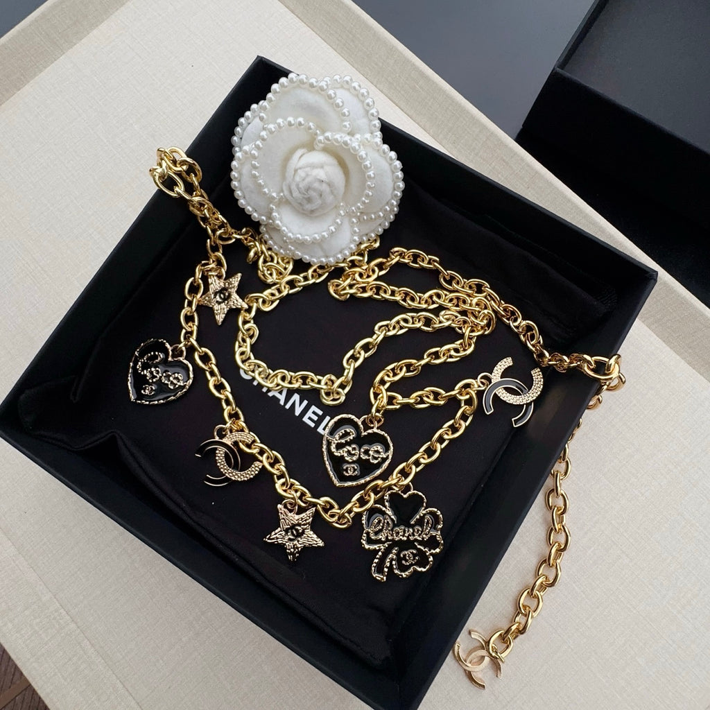 Gold-tone chain belt with heart, star, and CC logo charms on a link chain
