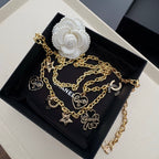 Gold-tone chain belt with heart, star, and CC logo charms on a link chain