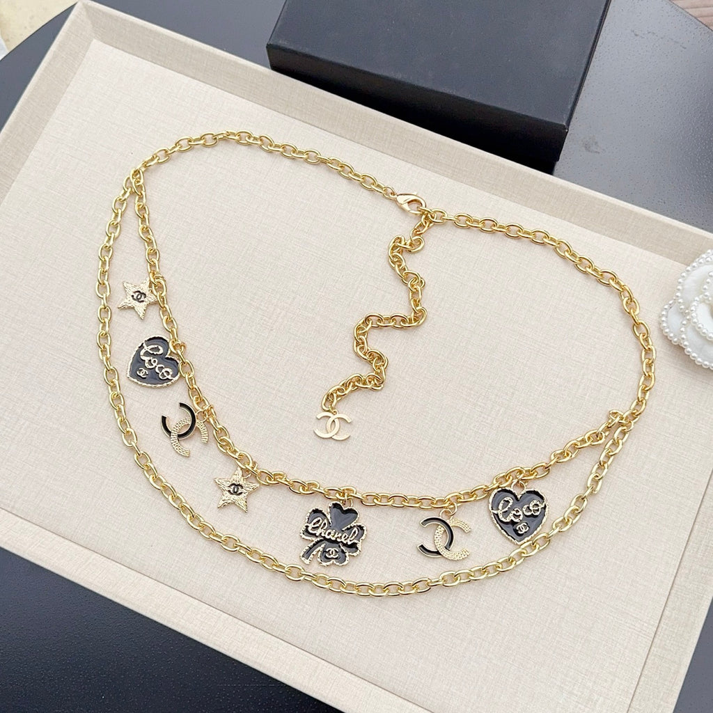 Gold-tone chain belt with black enamel CC charms and small pendant details