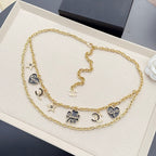 Gold-tone chain belt with black enamel CC charms and small pendant details