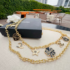 Gold-tone chain belt with CC medallion, star pendants, and heart and flower charms