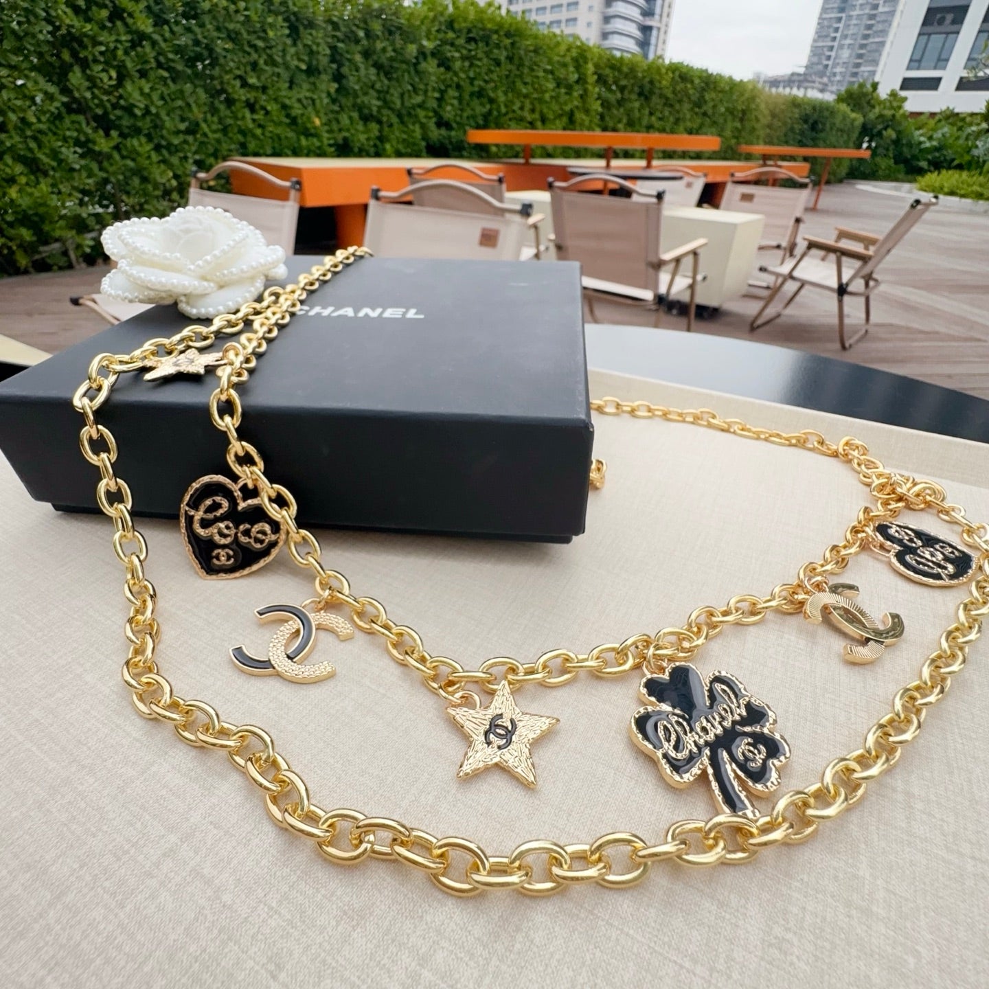 Gold-tone chain belt with CC medallion, star pendants, and heart and flower charms