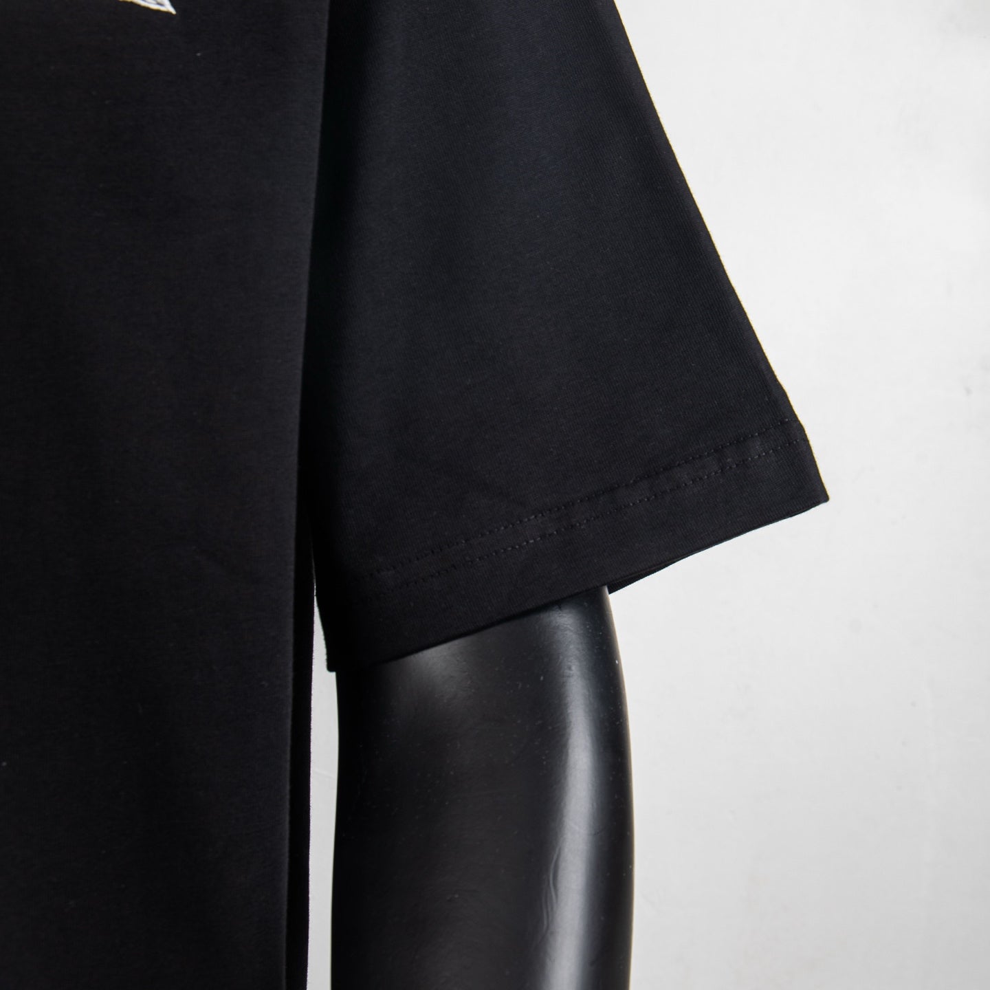 Givenchy black T-shirt sleeve and side seam close-up.