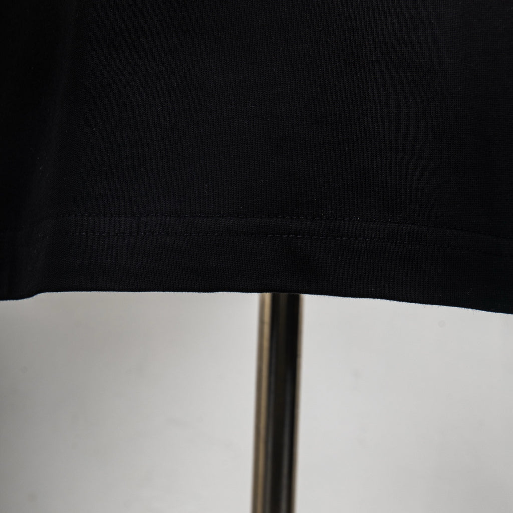 Givenchy black T-shirt hem and stitched seam close-up.