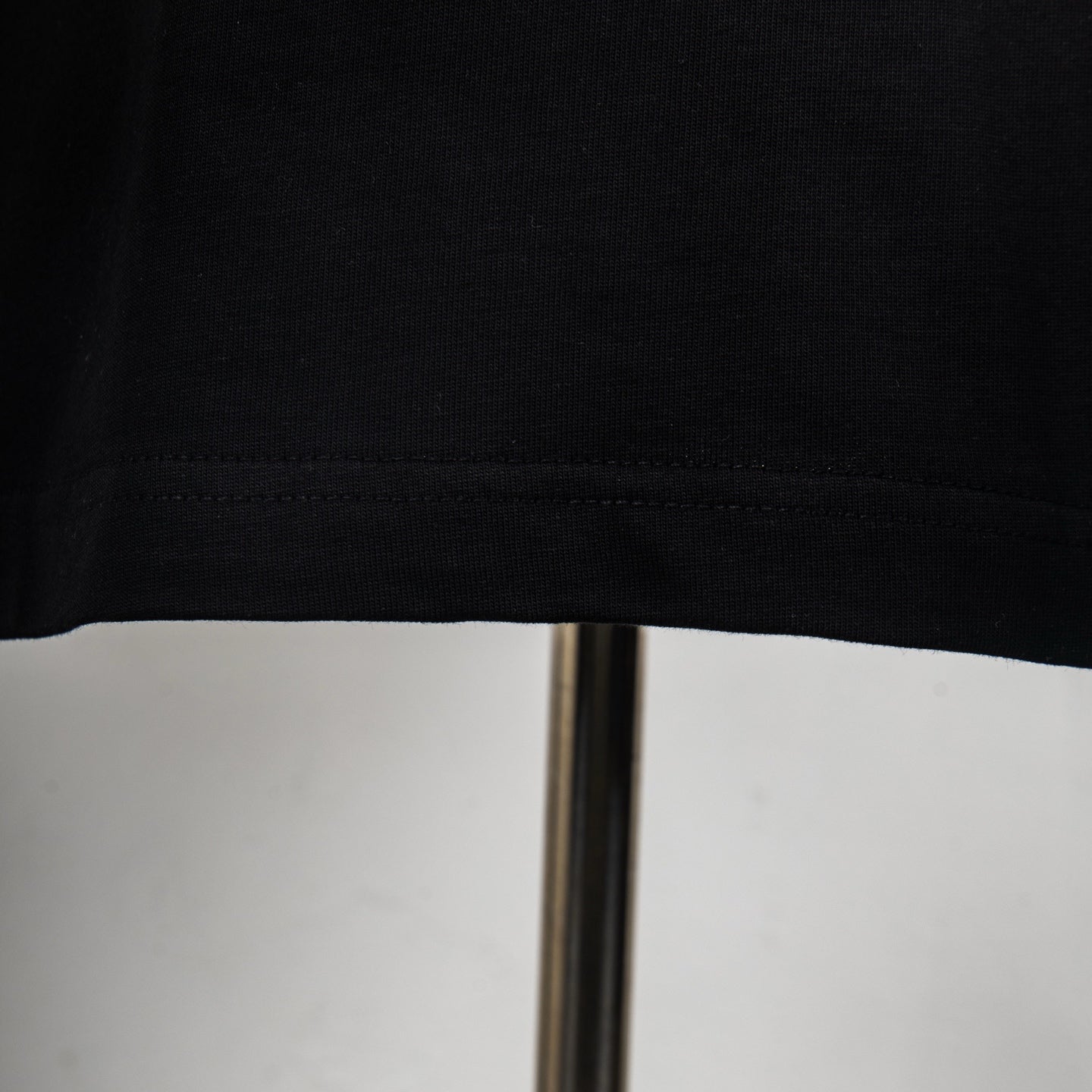 Givenchy black T-shirt hem and stitched seam close-up.