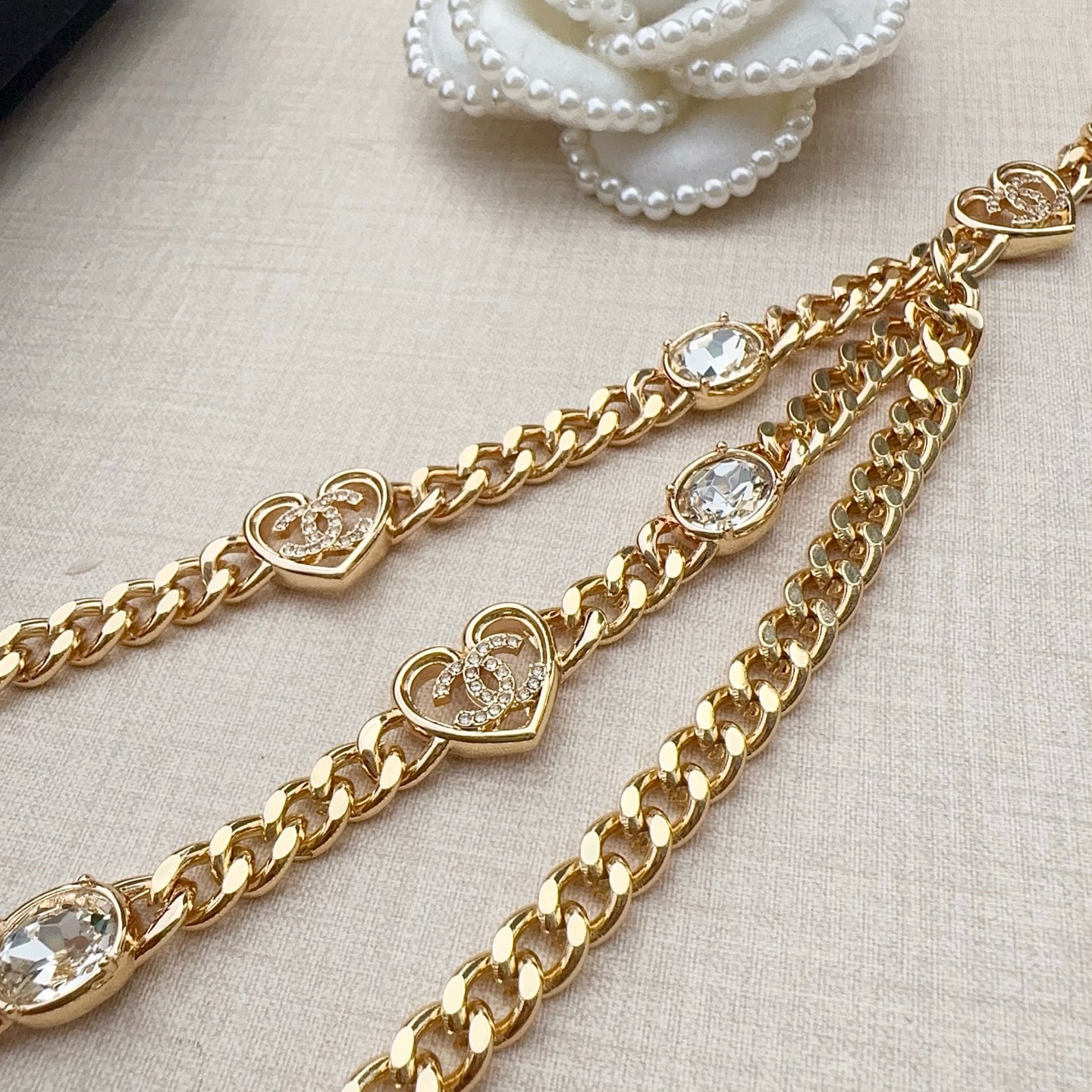 Chanel belt close-up with gold-tone chain, heart medallions, and clear crystal stones